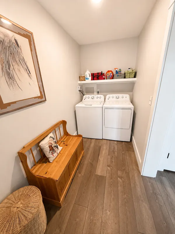 Laundry room with a washer, dryer, and wooden bench