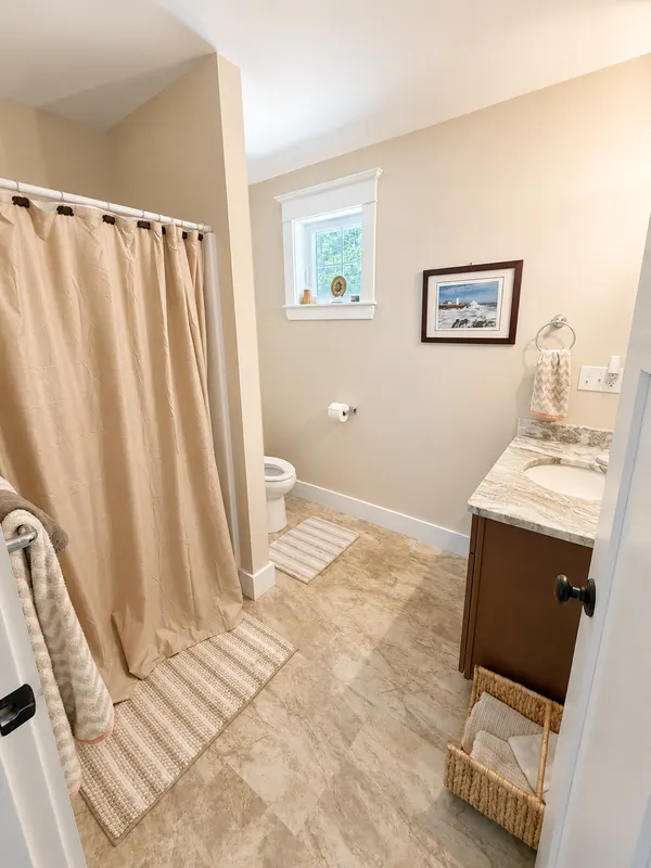 Guest bathroom with a shower and striped floor mats