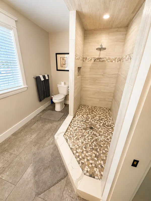 Master bathroom with a spacious stone-tiled walk-in shower