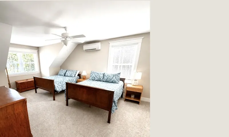 Second-floor guest bedroom with two full beds dressed in blue bedding